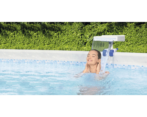 Frau entspannt sich im Pool unter einem Wasserfall