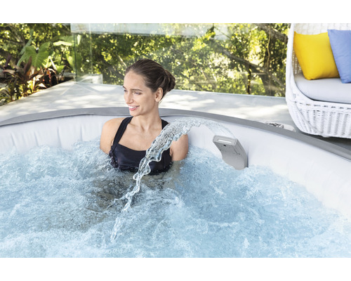 Frau entspannt in einem aufblasbaren Whirlpool mit Wasserfallfunktion im Freien.