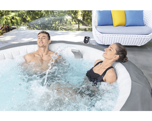 Aufblasbarer Whirlpool mit zwei entspannten Personen im Garten.