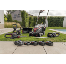 Akku-Gartengeräte-Set mit Rasenmäher, Kettensäge, Heckenschere und Akkus auf Rasen