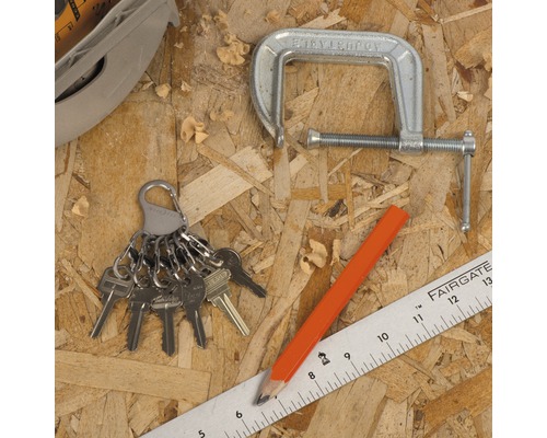 Werkbank mit Schraubzwinge, Schlüsselbund, Bleistift und Lineal