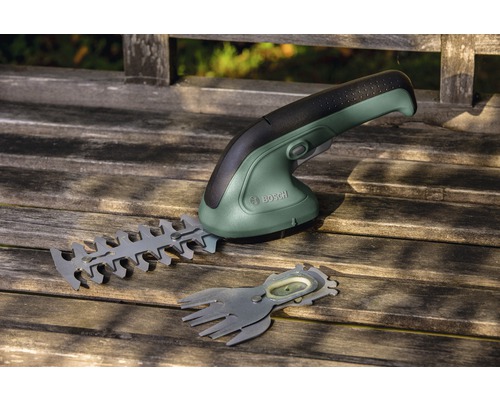 Bosch Akku-Grasschere mit Heckenscheren-Aufsatz auf einer Holzbank