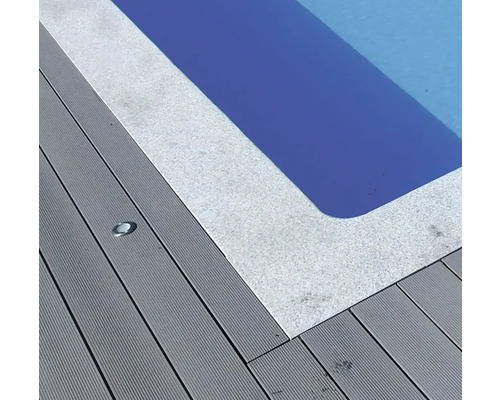 Nahaufnahme eines Pools mit grauem Beckenrand und grauer Holzterrasse mit eingelassenem Licht
