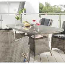 Esstischgruppe aus Rattan mit Glasplatte, Stühlen und Dekoration auf einer Terrasse