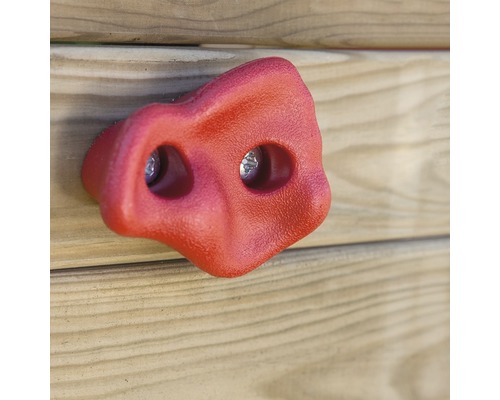 Roter Klettergriff aus Kunststoff an einer Holzwand
