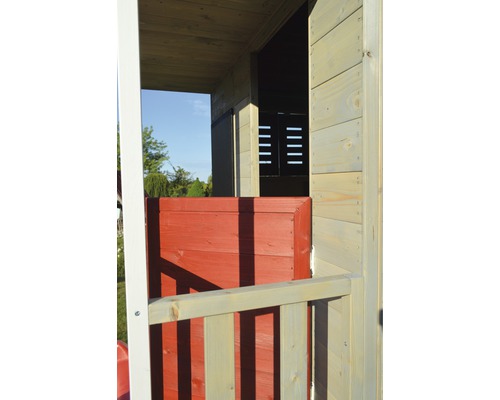 Detailansicht eines Holzspielhauses mit roter Tür und Holzgeländer