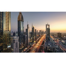 Skyline von Dubai mit Hochhäusern und Straßen bei Sonnenuntergang.