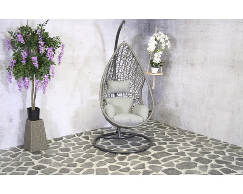 Szene mit einem Hängekorbsessel, einer künstlichen Glyzinienpflanze und einer hängenden Orchidee.