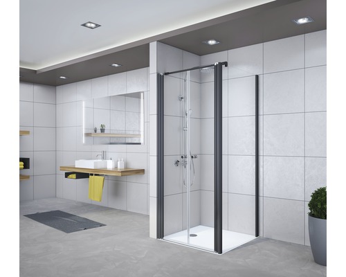 Modernes Badezimmer mit Duschkabine mit schwarzem Rahmen und Glaswänden, Waschtisch mit Spiegel und Ablageflächen.