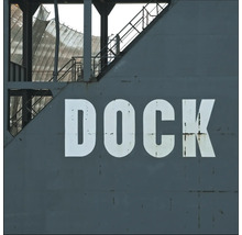 Detailaufnahme einer grauen Hafenanlage mit der Aufschrift Dock