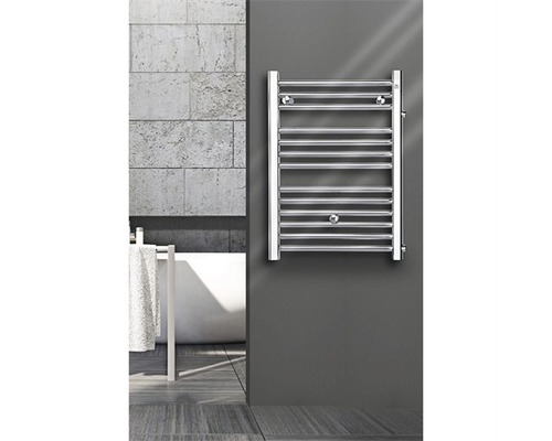 Badheizkörper Made by Zehnder 1200x600 mm chrom mit Mittelanschluss Chromfarbener Badheizkörper an einer grauen Wand neben einer Badewanne