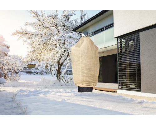 Winterlandschaft mit Pflanzenschutzsack im Garten