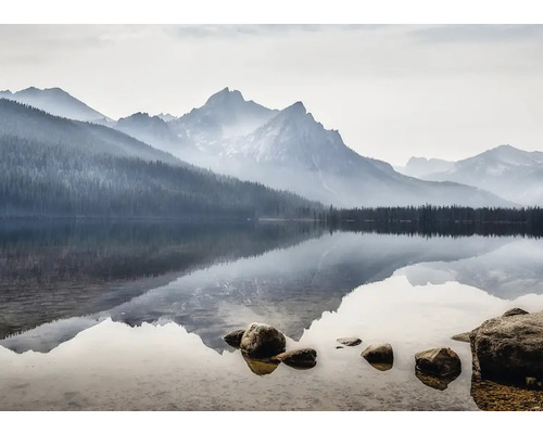 Bergsee mit Spiegelung der Berge und Bäume im Wasser