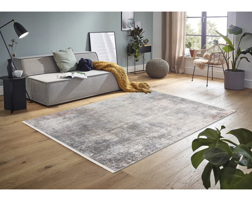 Wohnzimmer mit Sofa und abstraktem Teppich auf Holzboden