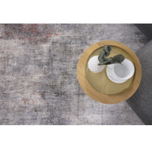 Teppich mit abstraktem Muster und ein Beistelltisch mit Dekoration.