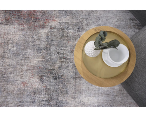 Teppich mit abstraktem Muster und ein Beistelltisch mit Dekoration.