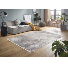 Wohnzimmer mit Sofa, Sessel und abstraktem Teppich auf Holzboden