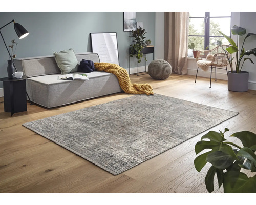 Wohnzimmer mit abstraktem Teppich, Couch und Dekoration