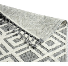 Detailansicht eines Teppichs mit geometrischem Muster und Fransen