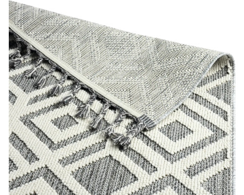 Detailansicht eines Teppichs mit geometrischem Muster und Fransen