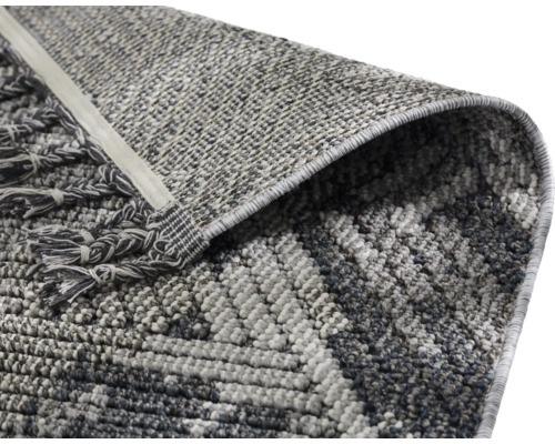 Detailansicht eines Teppichs mit geometrischem Muster und Fransen