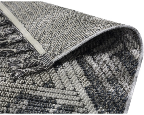 Detailansicht eines grauen Teppichs mit Fransen