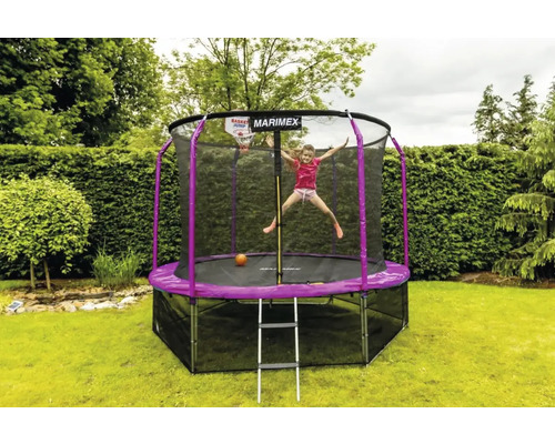 Mädchen springt auf einem Gartentrampolin mit Sicherheitsnetz und Basketballkorb