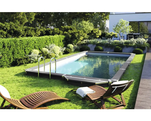 Rechteckiger Pool mit Leiter in einem gepflegten Garten mit Liegestühlen