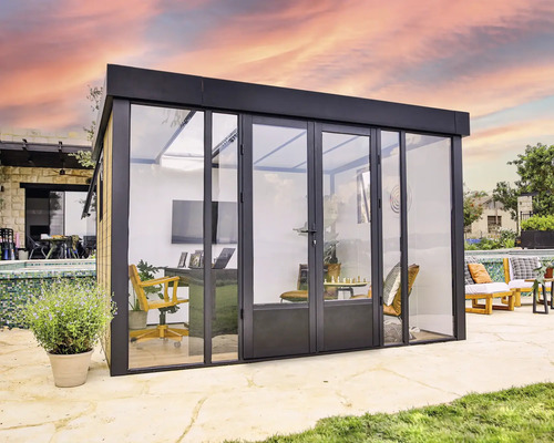 Modernes Gartenbüro mit Glasfront und Schiebetüren, ausgestattet mit Büromöbeln und dekorativen Elementen