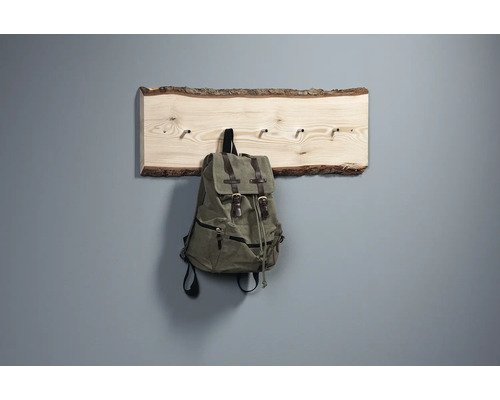 Garderobe aus Holz mit Rinde und einem Rucksack daran