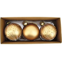 Drei goldfarbene Weihnachtskugeln in einer Pappschachtel