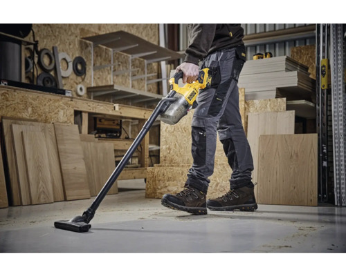 Ein Arbeiter benutzt einen Akku-Staubsauger von DeWalt in einer Werkstatt.