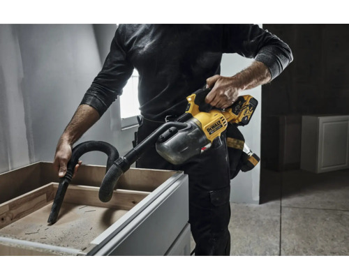 Ein Mann verwendet einen Handstaubsauger von DeWalt, um einen Schrank auszusaugen.
