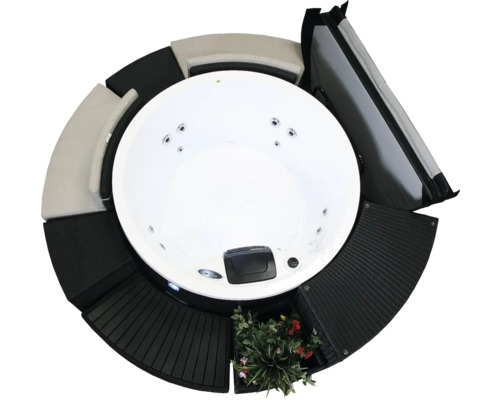 Runder Whirlpool mit Abdeckung und schwarzer Verkleidung mit Pflanzen