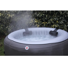 Aufblasbarer Whirlpool mit Kopfstützen und sprudelndem Wasser vor Pflanzen