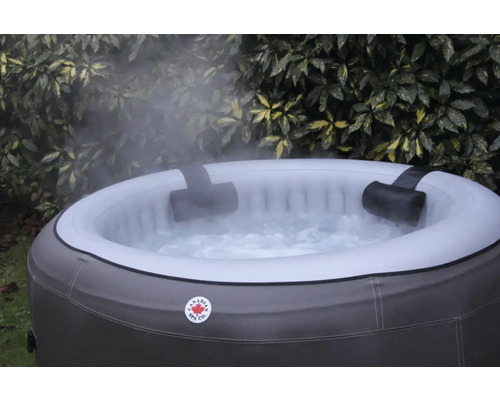 Aufblasbarer Whirlpool mit Kopfstützen und sprudelndem Wasser vor Pflanzen
