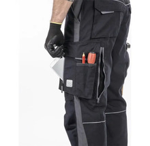 Detailaufnahme einer Arbeitshose mit mehreren Taschen, in denen sich ein Tablet, ein Stift und ein Schraubendreher befinden