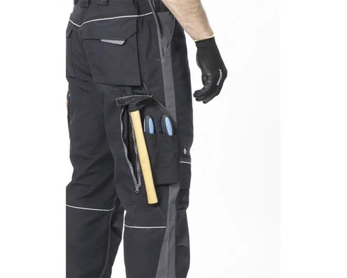 Detailaufnahme einer Arbeitshose mit Werkzeugen in den Taschen und einem Arbeitshandschuh