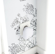 Elektrisches Gerät in Steckdose vor floraler Wand