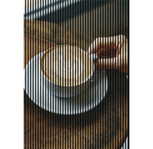 Eine Tasse Cappuccino auf einem Holztisch mit einer Hand, die nach der Tasse greift.