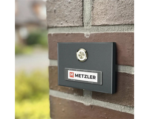 Metall Türklingel mit Namensschild an einer Backsteinmauer
