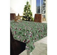 Festliche Tischdekoration mit einer grünen Tischdecke mit Weihnachtsmotiven in einem weihnachtlich geschmückten Raum.