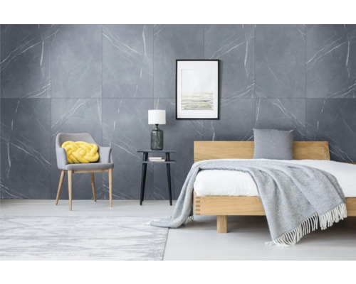 Heller Schlafraum mit Bett, Stuhl und Wandfliesen in Marmoroptik