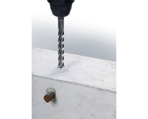 Ein Betonbohrer bohrt ein Loch in einen Betonblock.