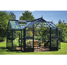 Gewächshaus mit Pflanzen und Sitzgruppe im Garten