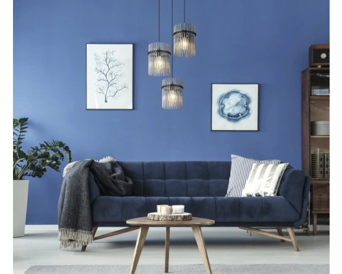 Wohnzimmer mit Sofa, Tisch, Zimmerpflanze und drei Pendelleuchten