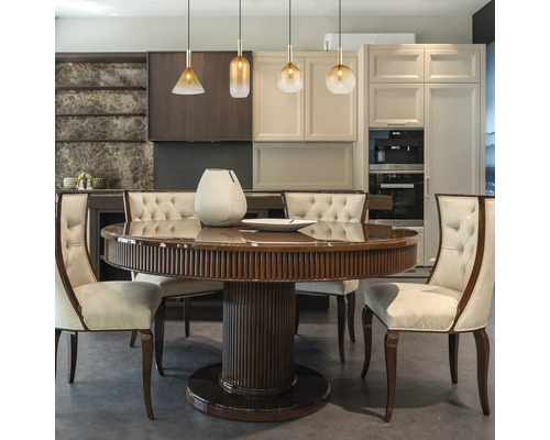 Esszimmer mit rundem Holztisch und gepolsterten Stühlen unter Pendelleuchten