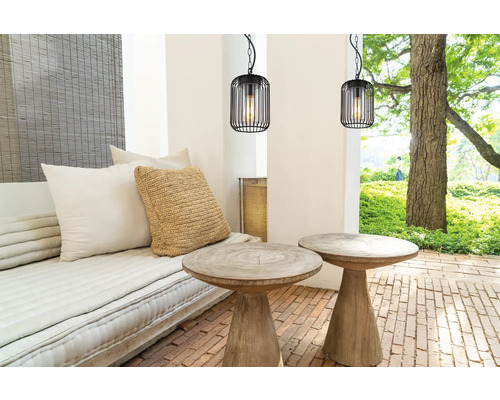 Terrasse mit Sitzbereich, zwei Holztischen und zwei schwarzen Hängelampen