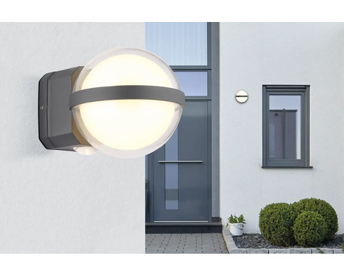 Leuchtende Außenleuchte mit Bewegungsmelder an einer Hauswand