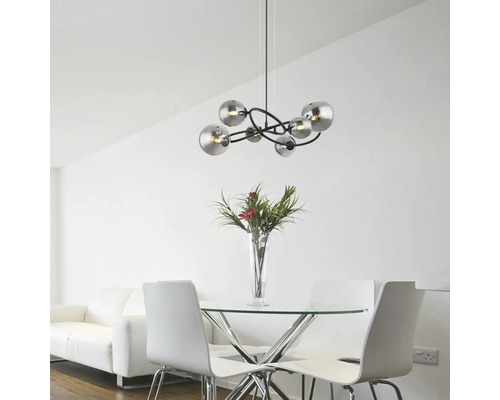 Moderne Pendelleuchte mit mehreren kugelförmigen Lampenschirmen über einem Esstisch in einem hellen Raum.